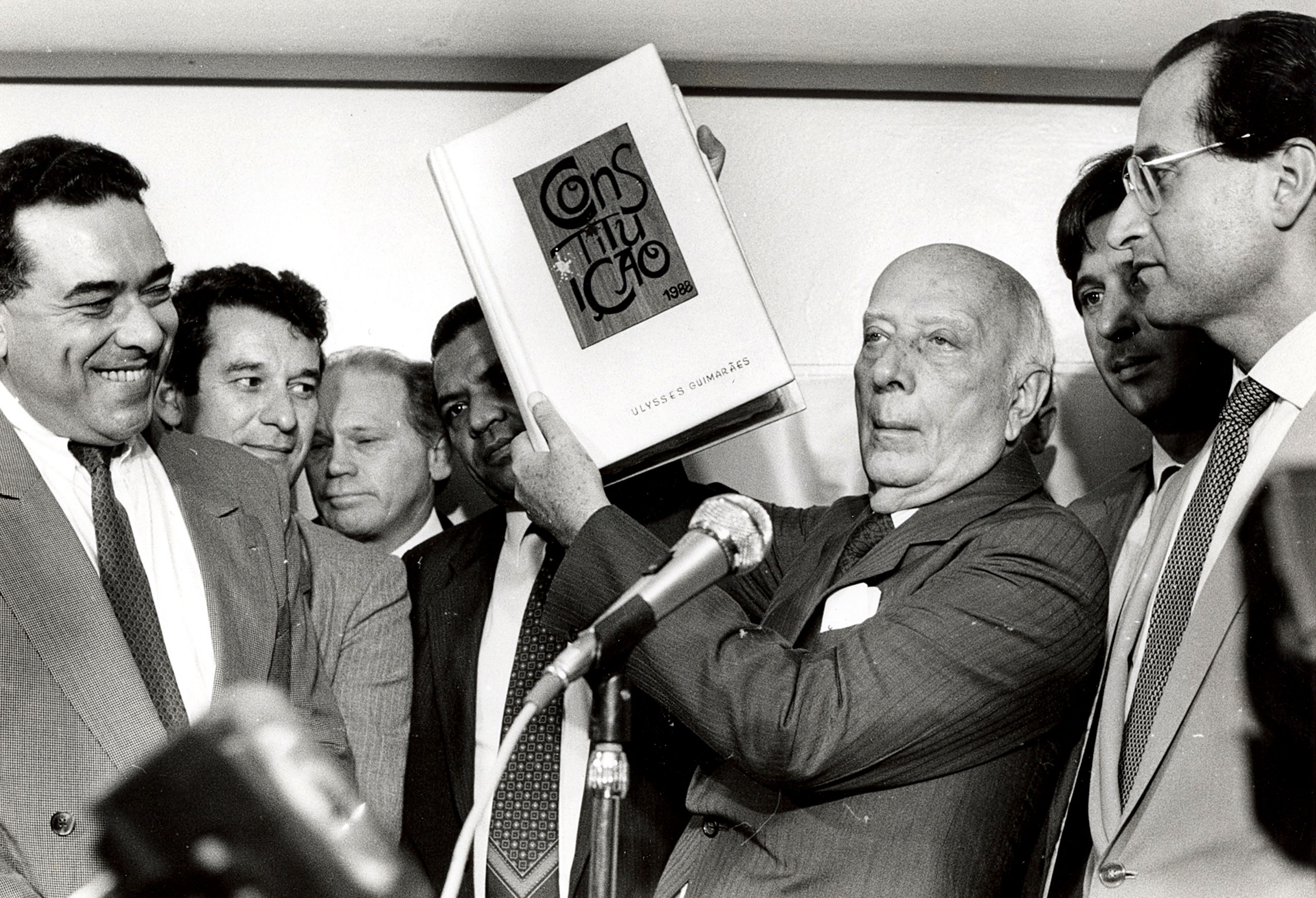 Ulysses Guimarães ergue um exemplar da Constituição Federal de 1988 (Foto: Fotos Públicas)
